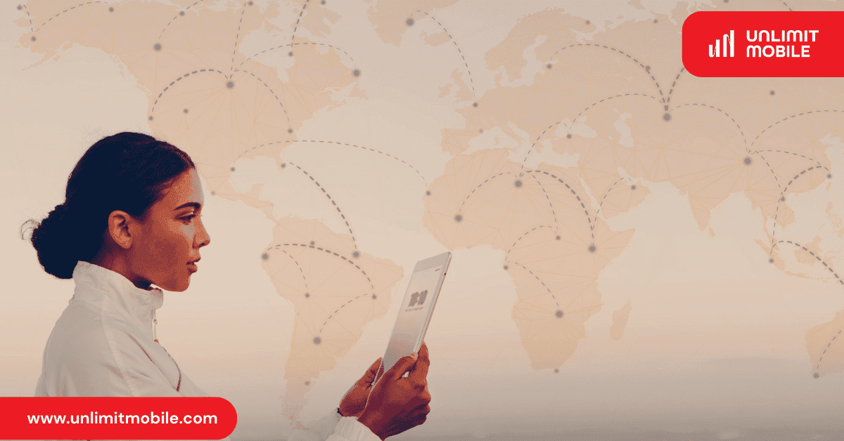 A woman holding a tablet with a QR code on screen, in front of a world map traced with flight routes